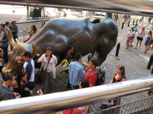 Tourists rub the Wall Street bull statue's testicles for financial good luck