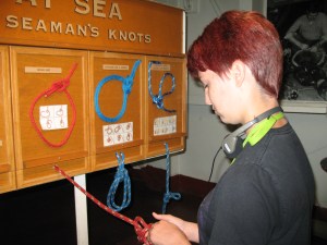 Laurel practices tying a knot aboard the USS Midway.