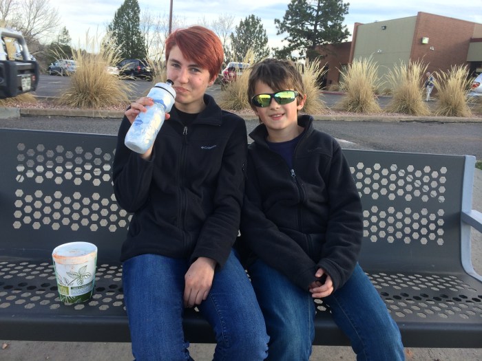 Waiting for an RTD bus while drinking our dinner from the water bottle...After visiting with Laura at South Glenn, we did a little grocery shopping at the Whole Foods there.  We'd only walked about a block and were near the bus stop when we noticed the soup we bought at Whole Foods was leaking all over the grocery bag.  Laurel's idea was to pour the soup into the water bottle that we brought with us which I did.  After we took turns guzzling that, I poured the other one in there.  Anyway, the water from that water bottle now tastes like tomato basil soup.  Isn't that a wonderful story?