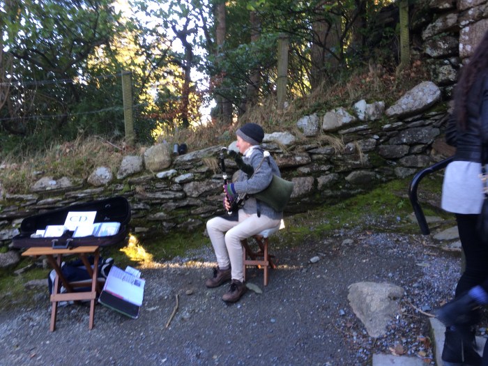 At St. Kevin's monastic city - the bagpiper pumps with her arm instead of blowing into the pipe with her mouth like a Scottish bagpiper.